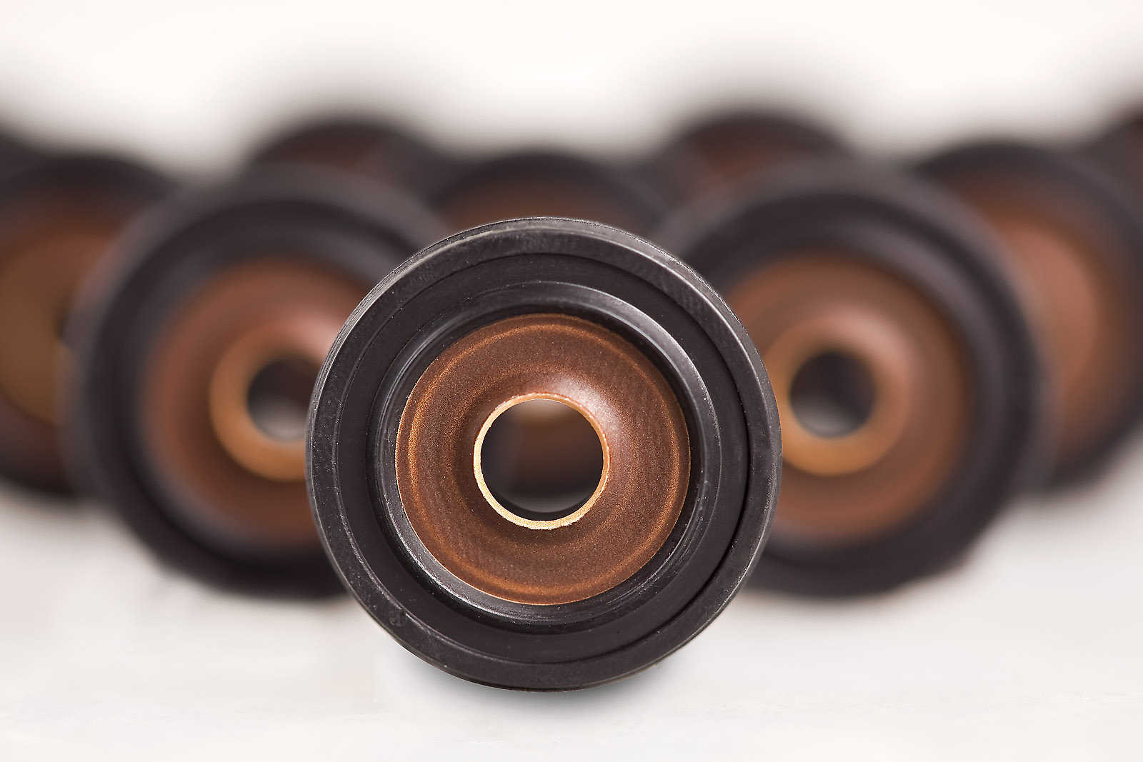 Gummi-Metall-Verbundteile, bei denen ein metallischer bronzefarbener Kern mit schwarzem Elastomer kombiniert ist