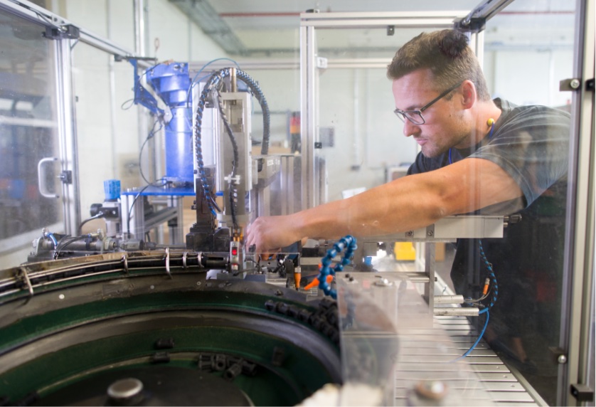 Ein Mitarbeiter richtet / überwacht eine Produktionszelle
